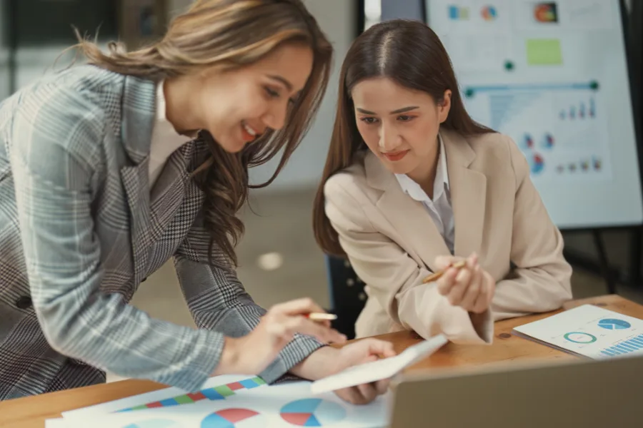 Business women calculating payment processing fees.