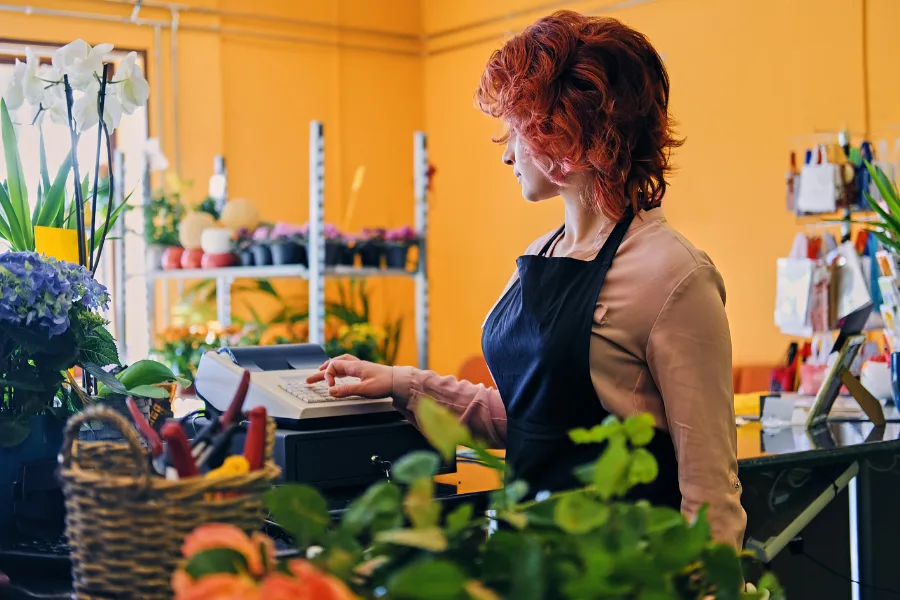 Cashier with an outdated cash register rather than a new POS system.