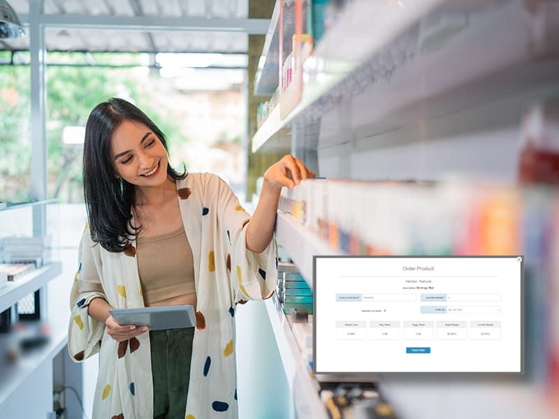 A smiling beauty store employee uses a tablet to manage inventory while standing beside neatly arranged products, showcasing a digital Beauty Supply POS System interface.